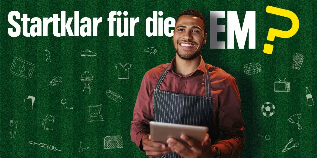 Ein lächelnder Mann steht vor einer grünen Wand mit dem Slogan Startklar für die EM