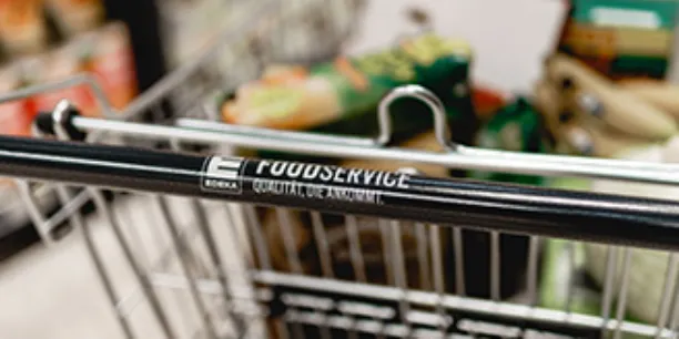 Mit Lebensmittel gefüllter Einkaufswagen. Auf der Handhabe steht EDEKA Foodservice.