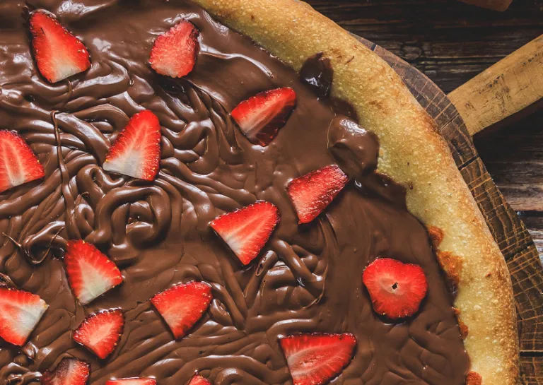 Pizza mit Nuss-Nougat-Creme und Beeren belegt
