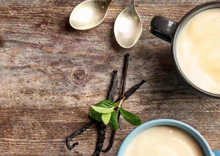 Glutenfreier Vanillepudding in Tassen auf Holztisch 