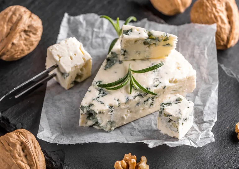Ein Stück Gorgonzola und Walnüsse auf einer Schieferplatte