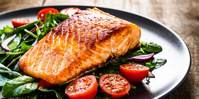 Gegrillter Lachs mit Tomaten auf einem Teller angerichtet