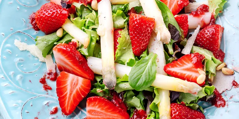 Erdbeer-Spargel Salat auf einem hellblauen Teller