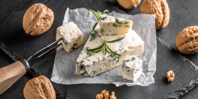 Ein Stück Gorgonzola und Walnüsse auf einer Schieferplatte