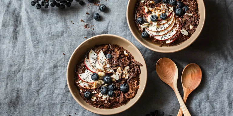 Zwei Bowls mit frisch zubereitetem Porridge und Obst