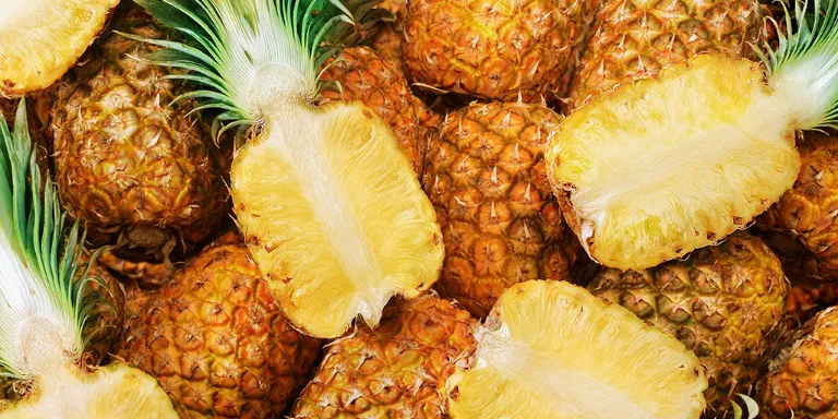 Ananas am Stück und aufgeschnitten nebeneinander