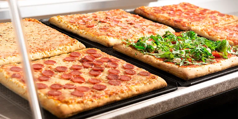 Ob im Bistro, Schwimmbad, in der Mensa oder auf einer Veranstaltung – ein Stück Pizza vom Blech ist eine beliebte Wahl.