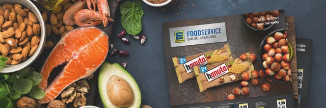 EDEKA Foodservice Handzettelwerbung liegt auf einem Tisch umgeben von frischen Lebensmitteln.