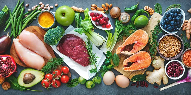 Verschiedene Lebensmittel sind nebeneinander platziert - von Fisch und Fleisch über Obst und Gemüse bis hin zu Nüssen und Hülsenfrüchten.