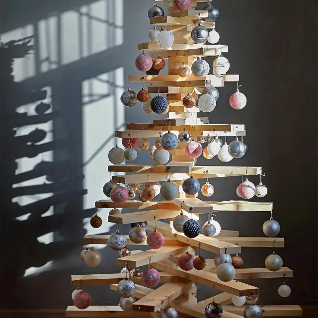 Weihnachtsbaum aus Holzlatten geschmückt mit bunten Kugeln