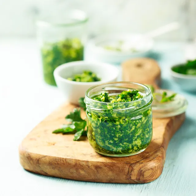 Mangold-Pesto im Glas auf einem Holzbrett