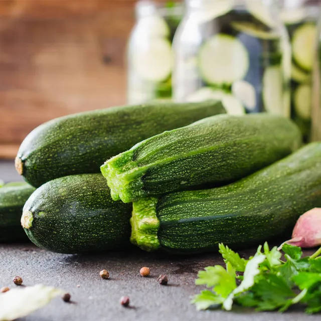 Mehrere Zucchini liegen aufrecht auf einem Feld