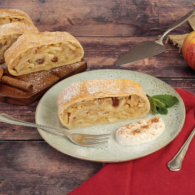 Apfelstrudel mit Sahne angerichtet auf einem Teller