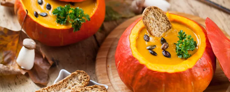 Kürbissuppe in einem ausgehöhlten Kürbis - Die farbenfrohen Herbstboten sind endlich wieder da und bereichern ab sofort unseren Speiseplan mit leckeren Kürbisgerichten. 